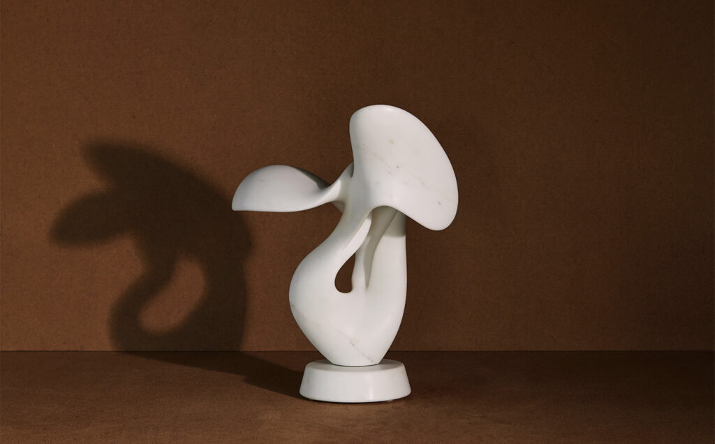 Marble Sculpture with shadow on brown background.