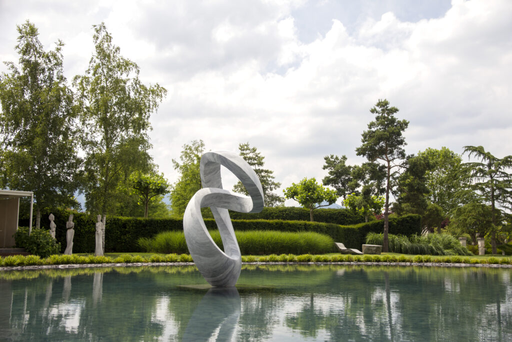 Bardiglio marble sculpture, Spira, sits in a pond at the Enea Tree Museum