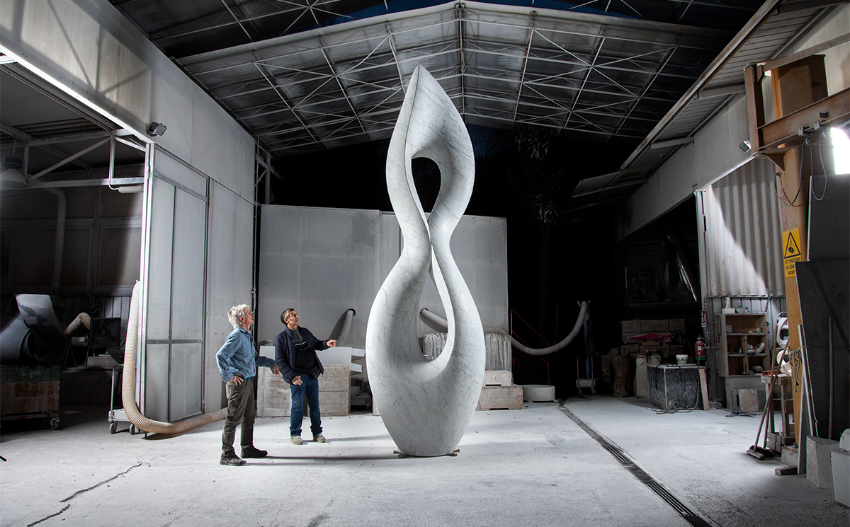 Sculptors admiring their monumental white Carrara marble sculpture, Belladonna